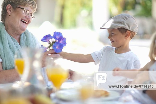 Junge schenkt Großmutter Blumen