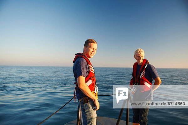 Portrait of two male lifeboat crew at sea