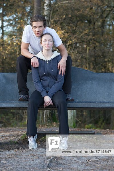 Paar auf Bank im Wald sitzend