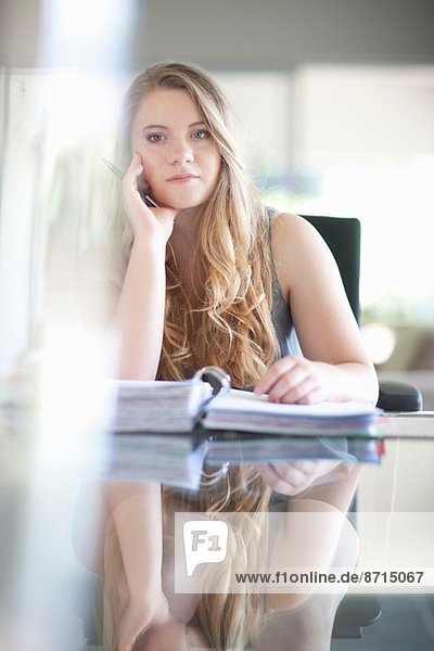 Young businesswoman looking bored with paperwork