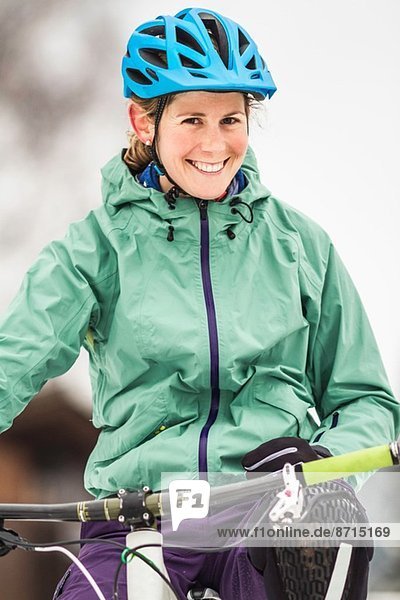 Portrait of smiling mid adult female mountain biker on bike