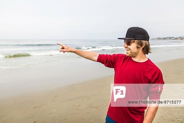 Young man pointing out to sea  Laguna Beach  California  USA