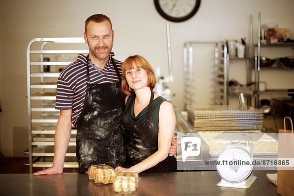 Portrait of baker couple behind kitchen counter