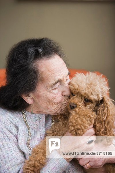 Seniorin küssender Hund