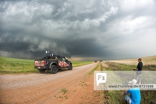 Stormchasers and TV channel nine reporting truck at scene of supercell thunderstorm near Sterling  Oklahoma  United States of America  North America