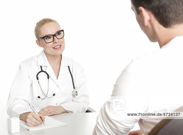 Junge Ärztin mit Brille  männlicher Patient  im Gespräch