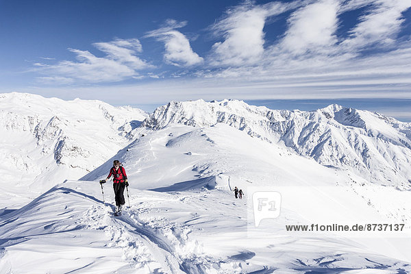 Skitourengeher auf dem Gipfelgrat vom Stotz bei Kurzras im Schnalstal  hinten die Grawand  Südtirol  Italien