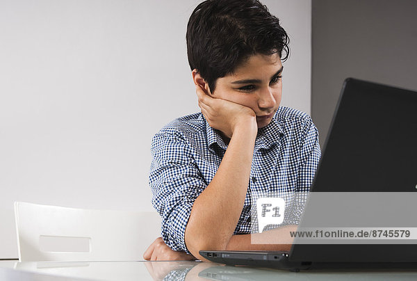 Teenage Boy using Laptop Computer  Studio Shot
