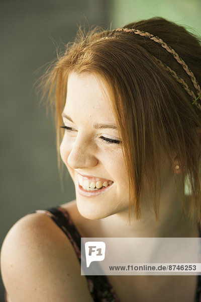 Portrait of teenage girl outdoors  looking downwards and laughing