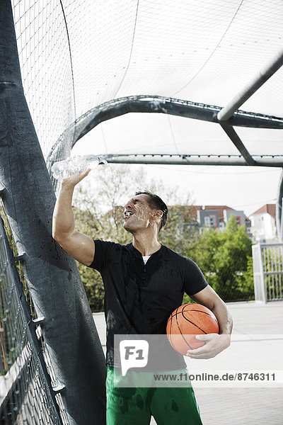stehend  Wasser  Mann  eingießen  einschenken  reifer Erwachsene  reife Erwachsene  Basketball  Außenaufnahme  Flasche  Gericht  Deutschland
