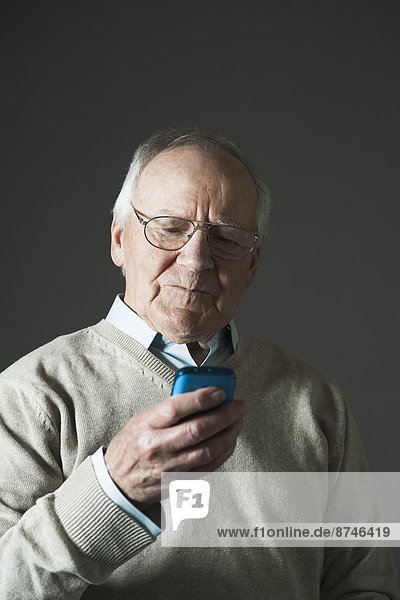 Elderly Man using Cell Phone in Studio
