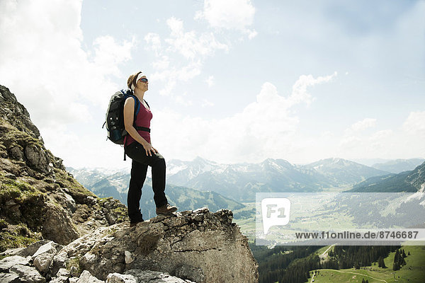 Mature woman standing on cliff  hiking in mountains  Tannheim Valley  Austria