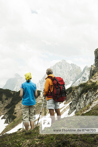 Backview of mature couple hiking in mountains  Tannheim Valley  Austria