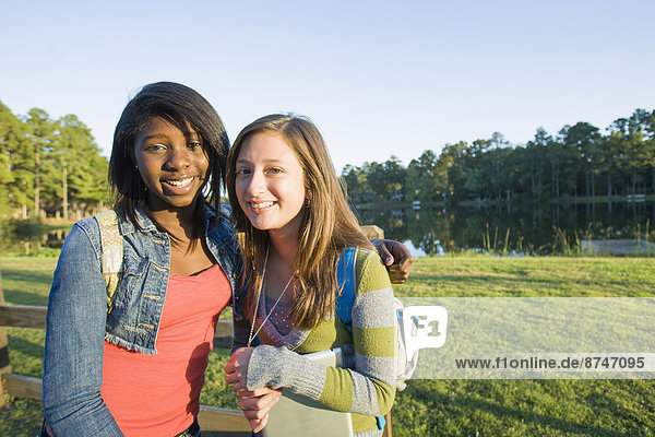 Portrait of pre-teen girls smiling and looking at camera  outdoors