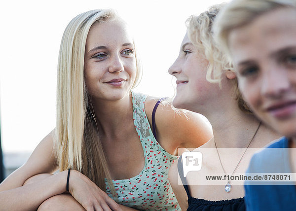 Close-up portrait of teenage girls and boy sitting outdoors  Germany