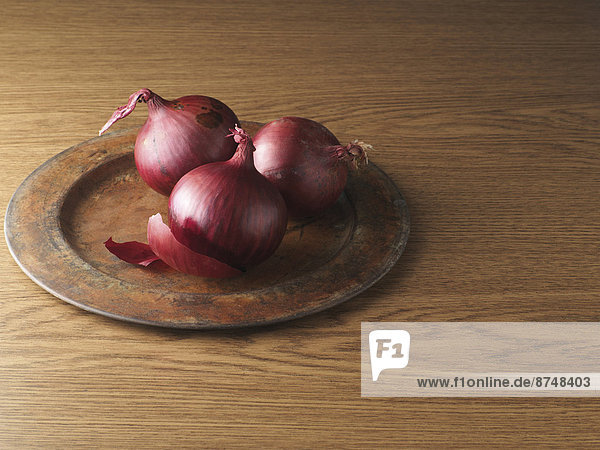 Red Onions on Metal Plate on Wooden Background  Studio Shot