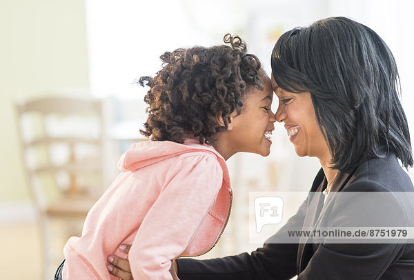 Black mother and daughter rubbing noses