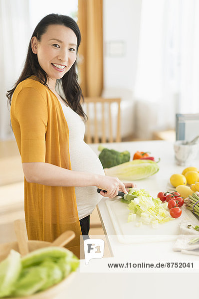Portrait Frau schneiden Küche Gemüse Schwangerschaft japanisch