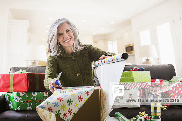 Portrait of Caucasian woman wrapping Christmas gifts