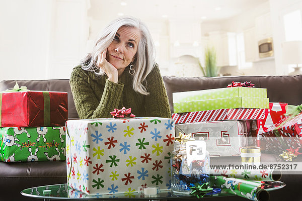 Irritated Caucasian woman wrapping Christmas gifts