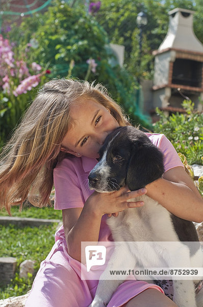 young girl with dog in garden