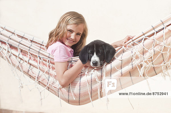 junges Mädchen mit Hund in Hängematte