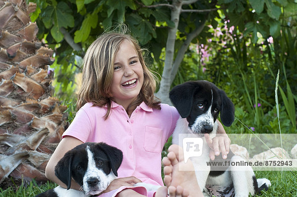 young girl with dogs in garden