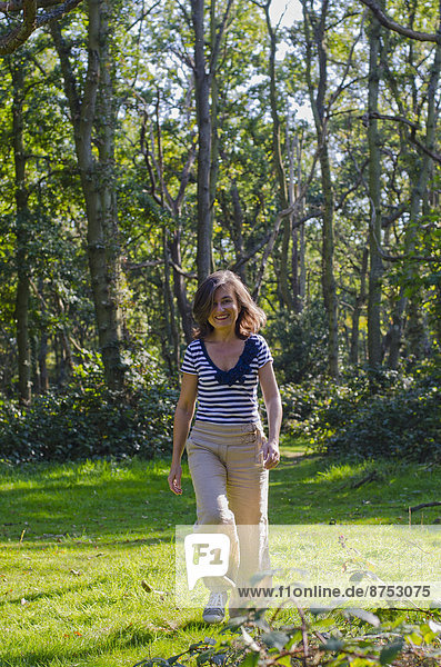 woman walking across clearing in forest