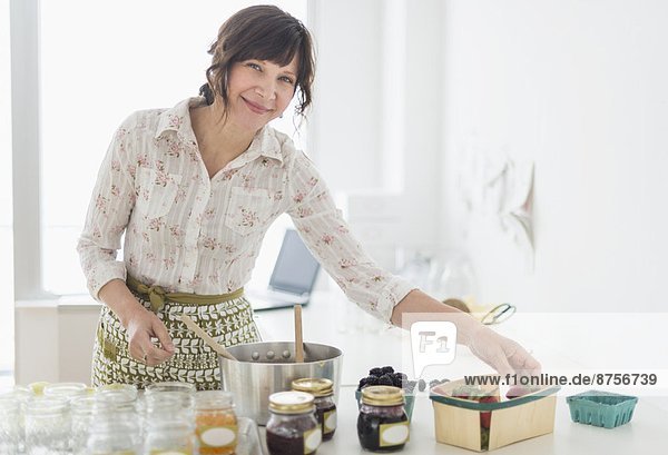 Woman making preserves in kitchen