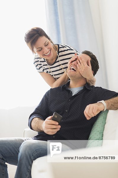 Woman covering man's eyes