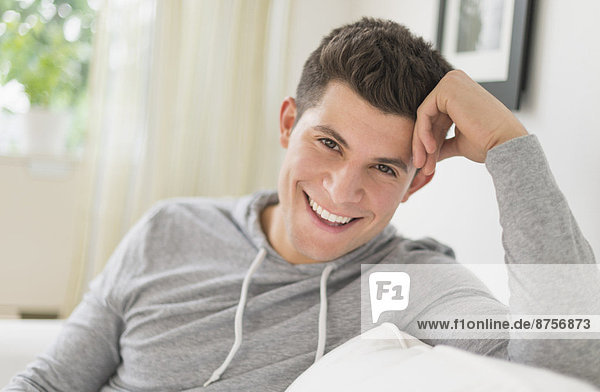 Young man sitting on sofa and smiling