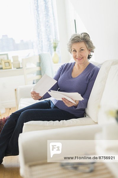 Woman sitting on coach reading letters