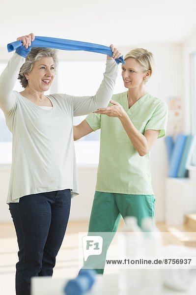 Mature woman exercising with personal trainer