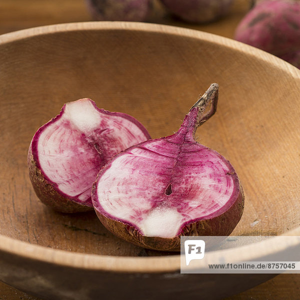 Studio shot cut Japanese red turnip in wooden bowl
