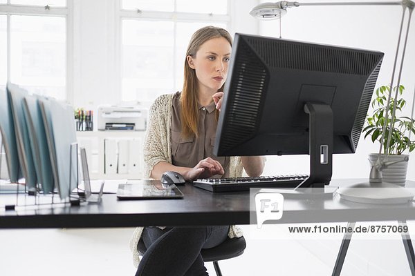 Portrait of young woman working on computer in office