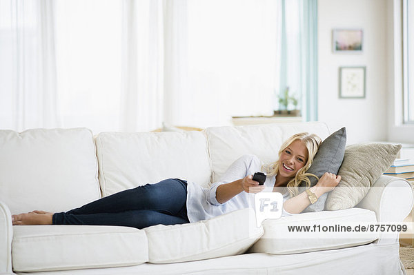 Young woman watching tv on sofa