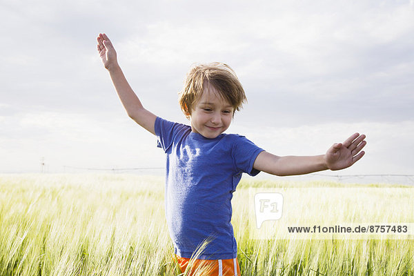 stehend  Junge - Person  heben  Gras  5-6 Jahre  5 bis 6 Jahre