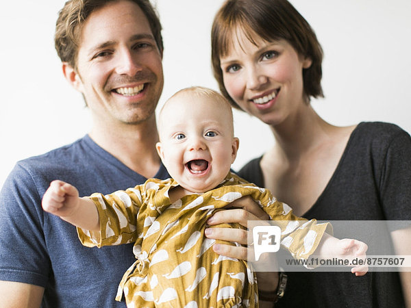 Studio portrait of parents with baby son (2-5 months)
