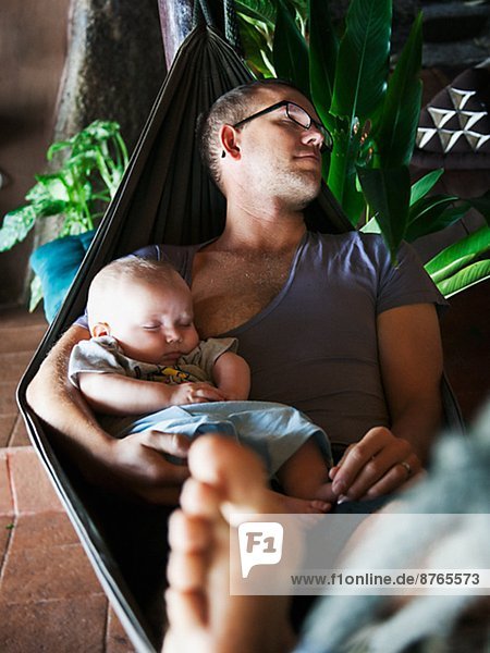 Father with baby seeping on hammock  Thailand