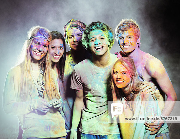Portrait of friends covered in chalk dye at music festival