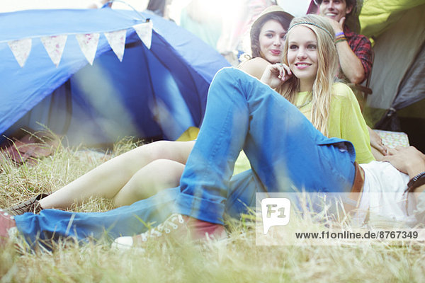 Friends relaxing outside tents at music festival