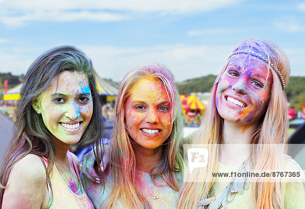 Portrait of smiling women covered in chalk dye at music festival