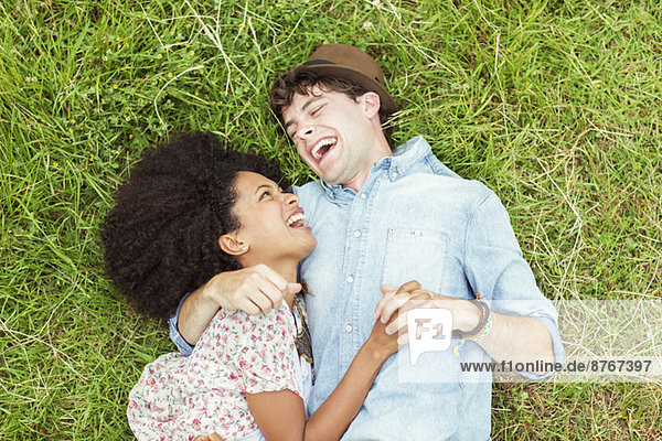 Lachendes Paar im Gras liegend