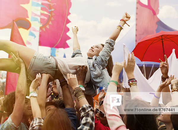 Woman crowd surfing at music festival