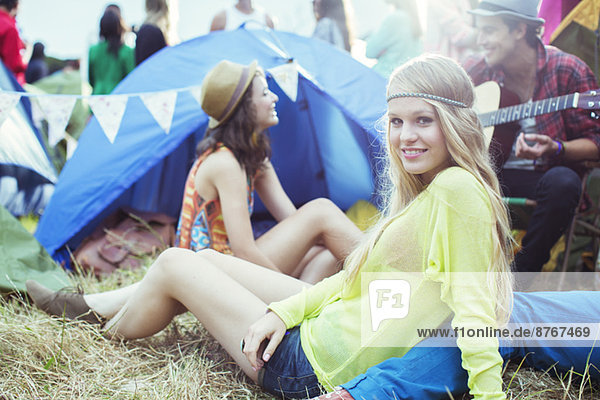 Porträt einer Frau  die mit Freunden vor dem Zelt beim Musikfestival rumhängt.