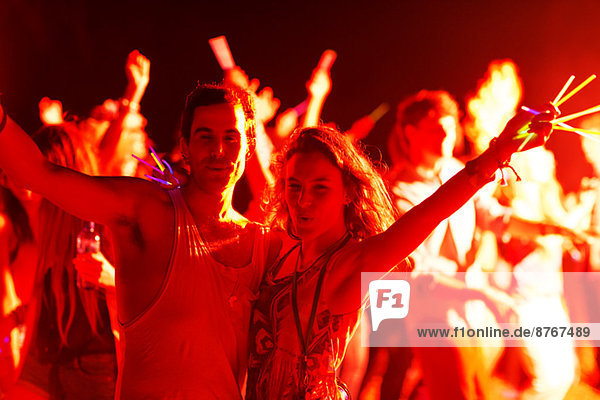 Porträt eines Paares mit Leuchtstäben beim Musikfestival