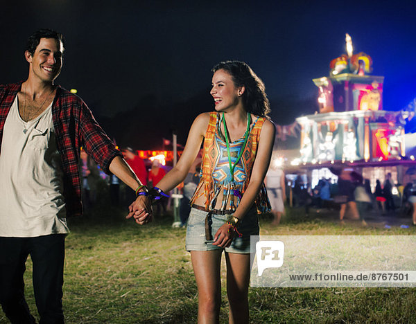 Paar hält sich an den Händen und verlässt das Musikfestival.