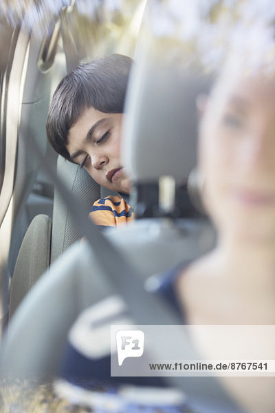 Junge schläft auf dem Rücksitz des Autos