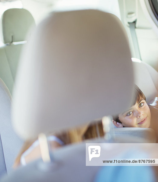 Mother turning to talk to children in back seat of car