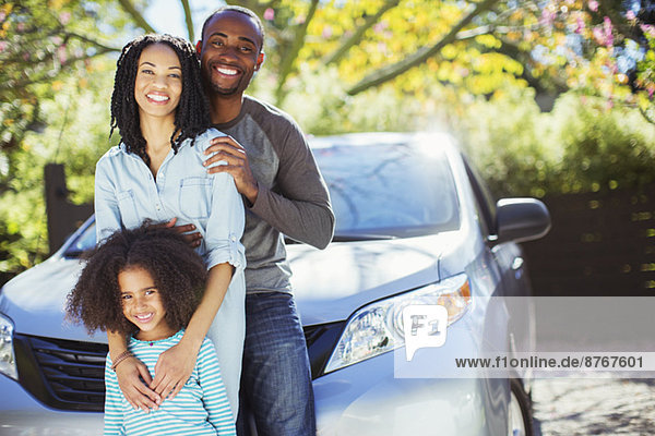 Porträt einer glücklichen Familie außerhalb des Autos